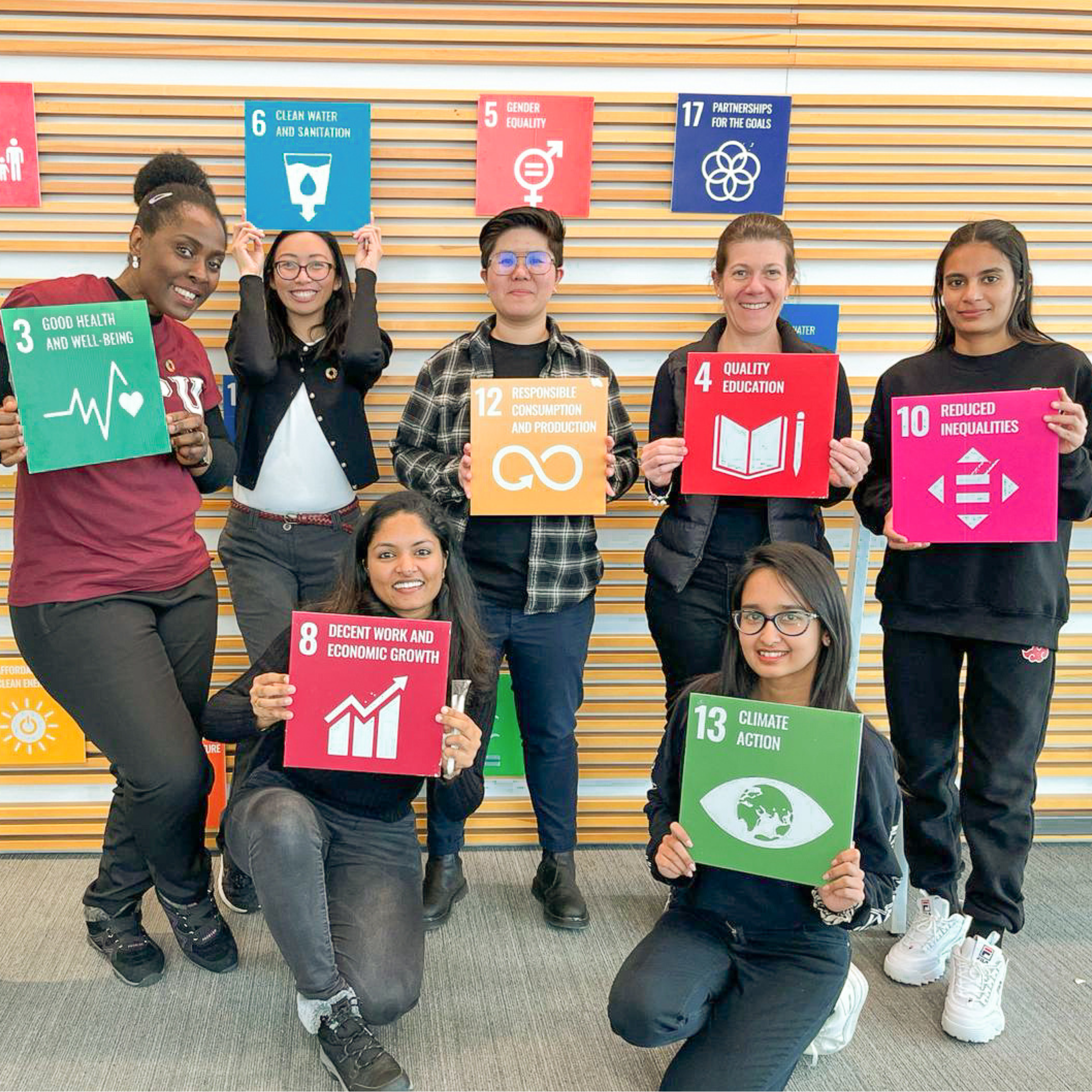 group of students holding colourful signs